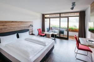 una camera con letto, tavolo e sedie di Restaurant & Landhotel Winter a Gomadingen