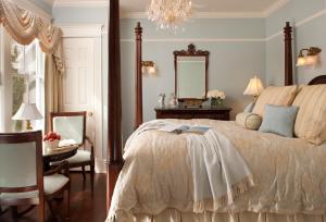 um quarto com uma cama, uma mesa e um espelho em The Tower Cottage Bed and Breakfast em Point Pleasant Beach