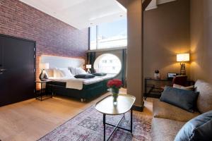 Cette chambre comprend un lit, un canapé et une table. dans l'établissement Solo Sokos Hotel Lahden Seurahuone, à Lahti