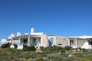 una casa en la playa con un cielo azul en Dune Ridge Main House, en Paternoster