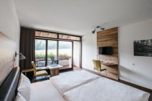 a bedroom with a bed and a desk and a table at Restaurant & Landhotel Winter in Gomadingen