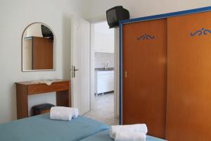 a bedroom with a bed and a mirror and a bathroom at Lena Studios in in Hanioti