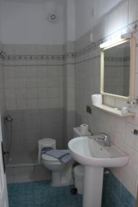 a bathroom with a sink and a toilet and a mirror at Lena Studios in in Hanioti +38 photos