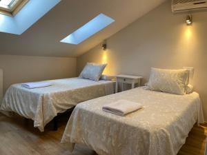 sypialnia z 2 łóżkami z białą pościelą i świetlikiem w obiekcie Fuencarral Apartments w Madrycie