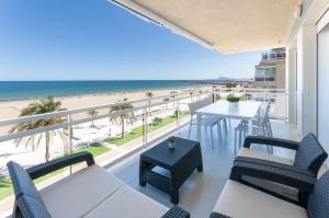 balcón con sillas y mesas y vistas a la playa en Ag Arena Suite Premium, en Gandía