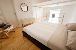 1 dormitorio con cama, silla y espejo en Scalo al Castello, en Locate di Triulzi