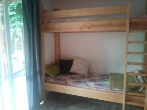 Ce lit superposé se trouve dans un dortoir avec une échelle. dans l'établissement Agrochillout Gospodarstwo agroturystyczne, à Zagnańsk Zachełmie