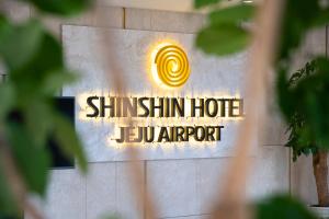 un cartello sul lato di un edificio con lo shima shim hotel le di Shin Shin Hotel Jeju Airport a Jeju