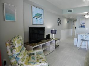 a living room with a couch and a flat screen tv at 17th Floor 1 BR Resort Condo Direct Oceanfront Wyndham Ocean Walk Resort Daytona Beach 1706 in Daytona Beach