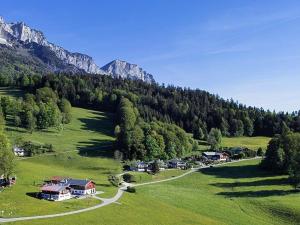 un grupo de casas en un campo verde con montañas en Haus Tauernblick, en Berchtesgaden