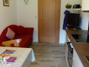 Una sala de estar con un sofá rojo y una mesa. en Haus Tauernblick, en Berchtesgaden