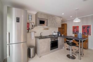una cucina con frigorifero in acciaio inossidabile e bancone di Apartment Abelha a Loulé
