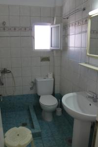 a bathroom with a toilet and a sink at Lena Studios in in Hanioti