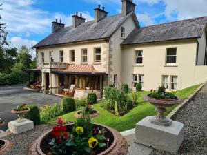 uma vista para o exterior de uma grande casa com um jardim em Banoge House em Donaghcloney
