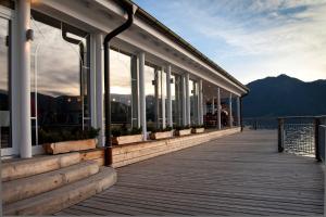 a building on a pier with windows and mountains at Clubhaus Bachmair Weissach in Tegernsee