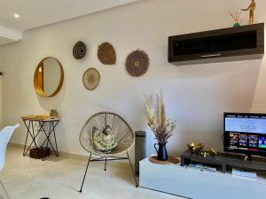 a living room with a television and a chair at Resort Style 2 Bedroom Apartment in the New Golden Mile FREE WIFI & PARKING in Estepona
