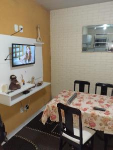 Recanto da natureza في سانا: غرفة مع طاولة وتلفزيون على الحائط