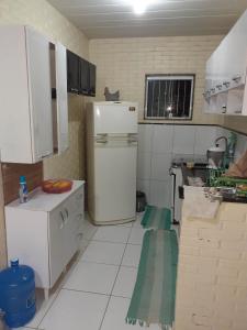 uma pequena cozinha com um frigorífico branco em Recanto da natureza em Sana