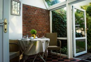 een tafel en stoelen op een veranda met een bakstenen muur bij Vila Josefina in Praag