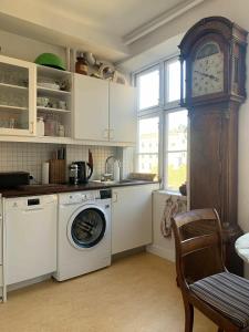 a kitchen with a washing machine and a clock at ApartmentInCopenhagen Apartment 1454 in Copenhagen