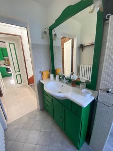 baño con lavabo verde y espejo en Villino Tarlarini, en Laveno-Mombello