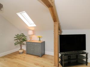 a living room with a flat screen tv and a table at Lugg View in Hereford