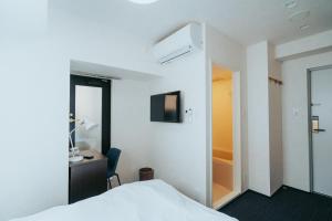 a bedroom with a bed and a desk and a mirror at unito SHIODOME in Tokyo