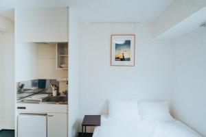 um quarto branco com uma cama e uma cozinha em unito SHIODOME em Tóquio