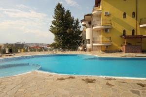 a large blue swimming pool next to a building at Menada Green Hills Apartments in Sozopol