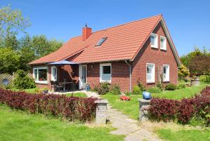 a red brick house with a red roof at Ferienwohnungen im Haus Trudi in Bensersiel