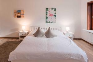ein Schlafzimmer mit einem weißen Bett und zwei Nachttischen in der Unterkunft Lund36 in Husum