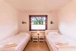 Dos camas en una habitación pequeña con ventana. en Lund36, en Husum