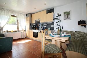 a kitchen and dining room with a table and chairs at Komfort Ferienwohnung FEWO74-1 in Bremm