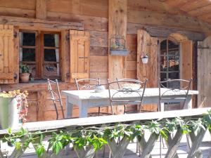 a table and chairs on the porch of a cabin at Charmant Mazot in Saint-Gervais-les-Bains