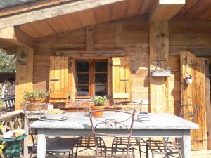 a patio with a table and chairs on a deck at Charmant Mazot in Saint-Gervais-les-Bains