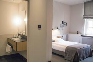 1 dormitorio con cama, lavabo y espejo en Apartment040, en Hamburgo