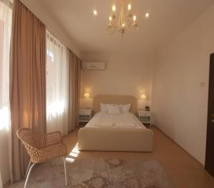 1 dormitorio con cama blanca y lámpara de araña en Princess Apartment en Sandanski