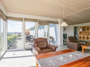 een woonkamer met lederen stoelen en een tafel bij 8 person holiday home in Skals in Sundstrup