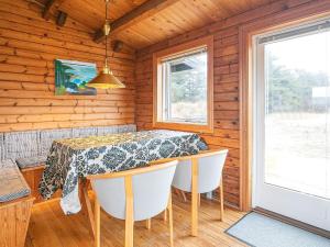 ein Esszimmer mit einem Tisch und Stühlen in einer Hütte in der Unterkunft 6 person holiday home in L kken in Løkken