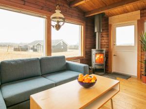 ein Wohnzimmer mit einem Sofa und einer Obstschale auf einem Tisch in der Unterkunft 6 person holiday home in L kken in Løkken