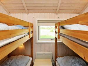 two bunk beds in a small room with a window at Holiday home Væggerløse XVI in Marielyst