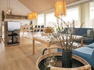 Brovstにある8 person holiday home in Brovstのリビングルーム(青いソファ、テーブル付)