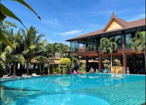 a large swimming pool in front of a building at Phi Phi Villa Resort-SHA Extra Plus in Phi Phi Islands