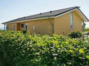 ein Haus mit einer Hecke davor in der Unterkunft 8 person holiday home in Sydals in Mommark