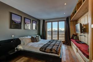 a bedroom with a bed and a large window at Chalet Auriane in Riddes