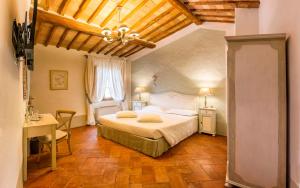 a bedroom with a bed and a table and a chair at Agriturismo Il Segreto di Pietrafitta in San Gimignano