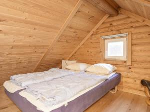 1 cama en una cabaña de madera con ventana en Holiday Home Torpet VI, en Hovborg
