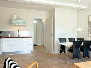 een keuken en eetkamer met een tafel en stoelen bij 6 person holiday home in Gudhjem in Gudhjem