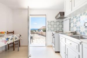 eine Küche mit einer Tür, die auf eine Terrasse führt in der Unterkunft Katerina Horizon Apartments by Konnect - 1,8km from Ipsos beach in Ýpsos