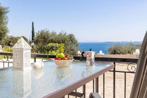 a table with a bowl of fruit on a balcony at Katerina Horizon Apartments by Konnect - 1,8km from Ipsos beach in Ipsos